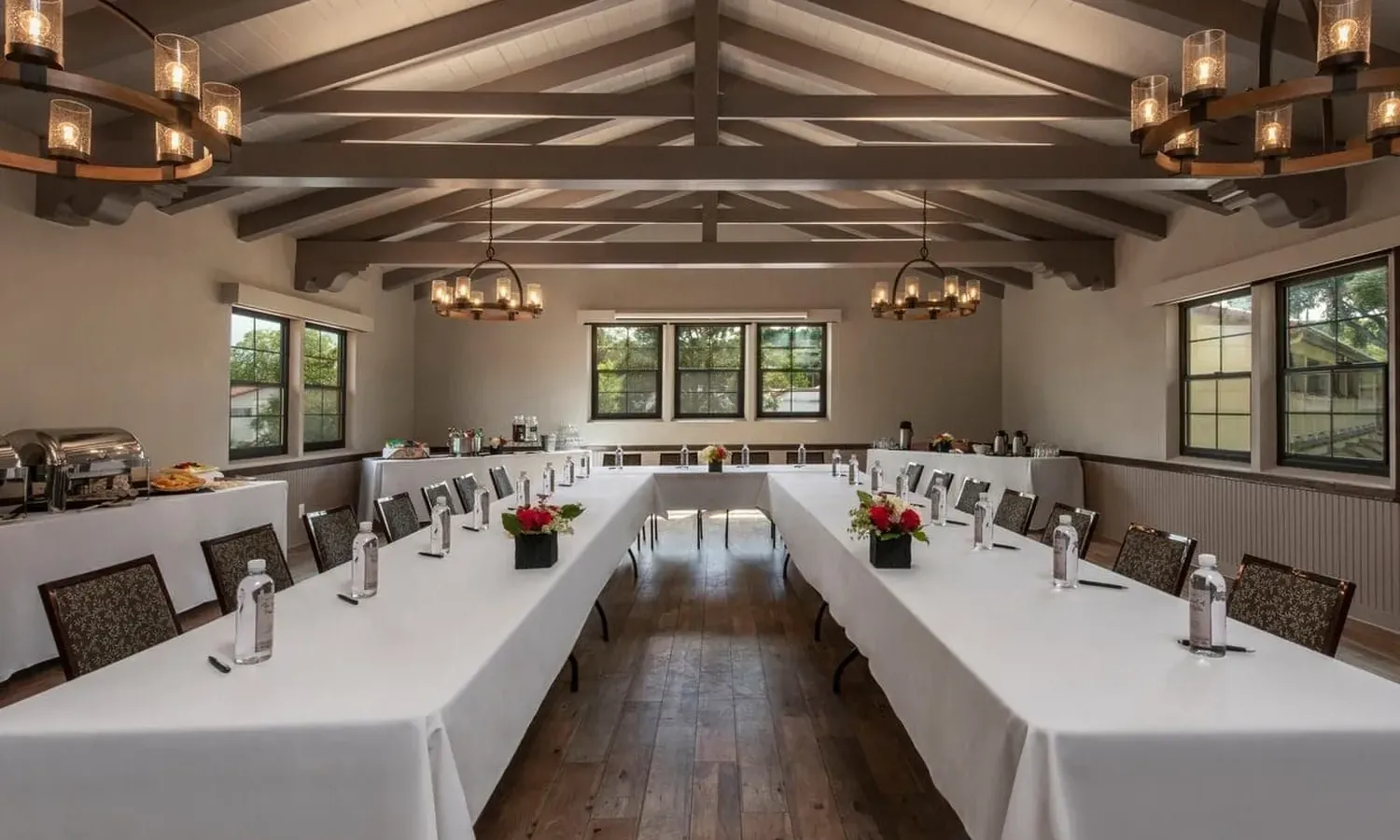 An inviting indoor dining area features rustic tables, string lights, and lush greenery, creating a cozy and charming atmosphere.