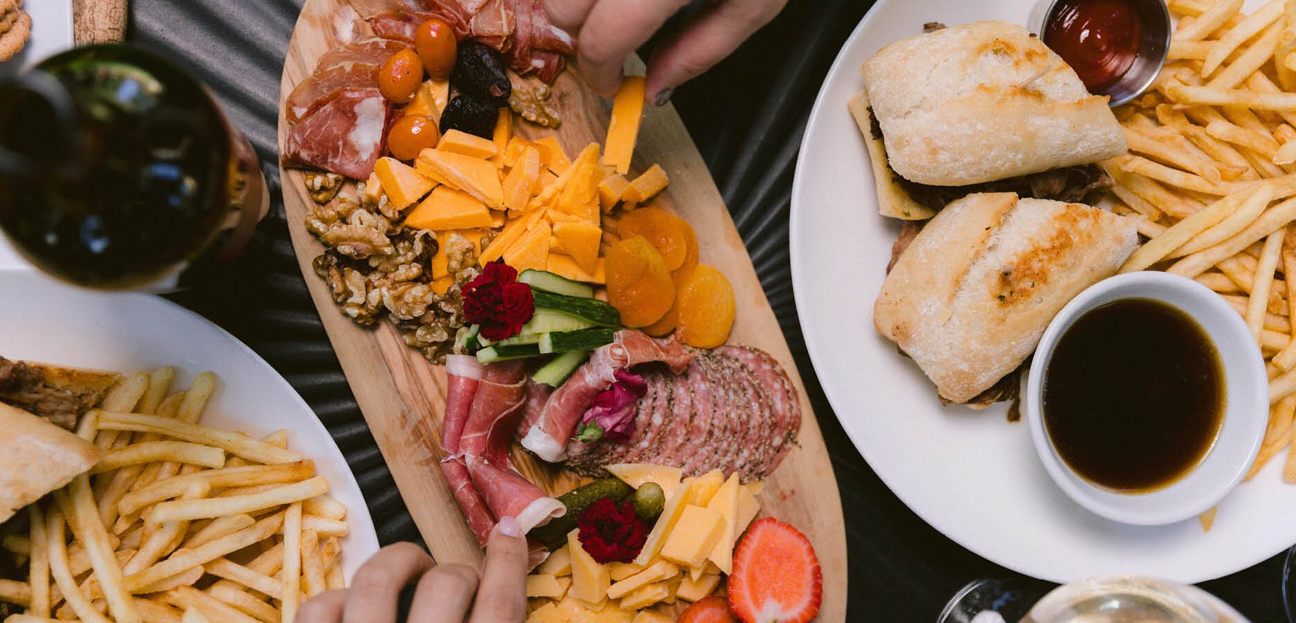 Charcuterie Board with hands reaching for food