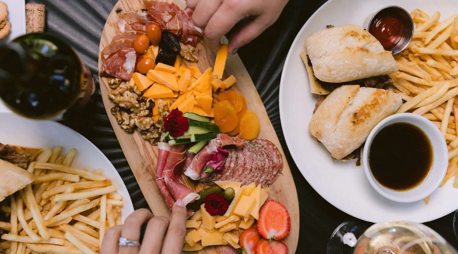 Charcuterie Board with hands reaching for food