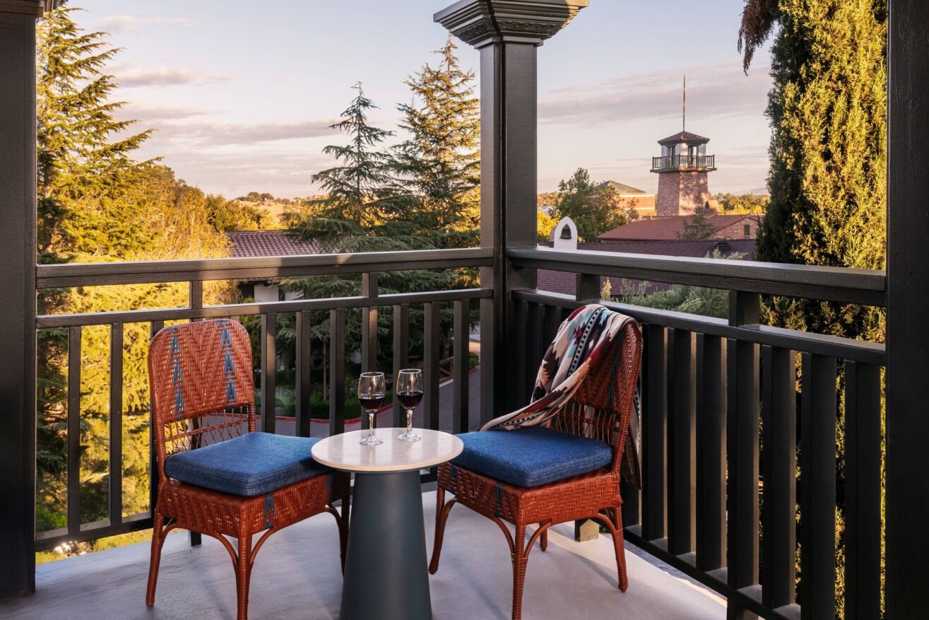 Two chairs on a balcony overlooking a tower