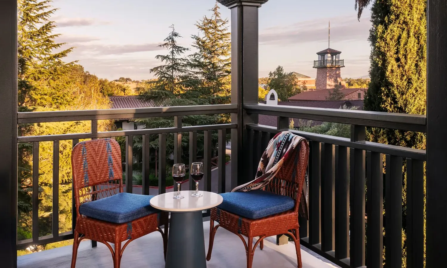 Two chairs on a balcony overlooking a tower