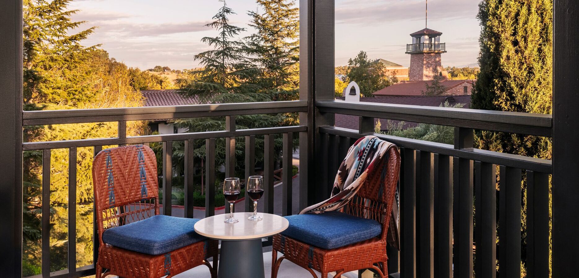Two chairs on a balcony overlooking a tower