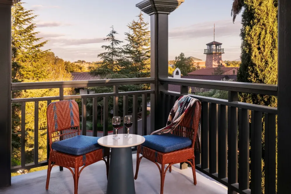 Two chairs on a balcony overlooking a tower